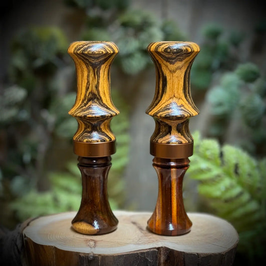A pair of golden and bronze bocote and cocobolo duck calls show the varied wood grain patterns that may be possible in your custom order