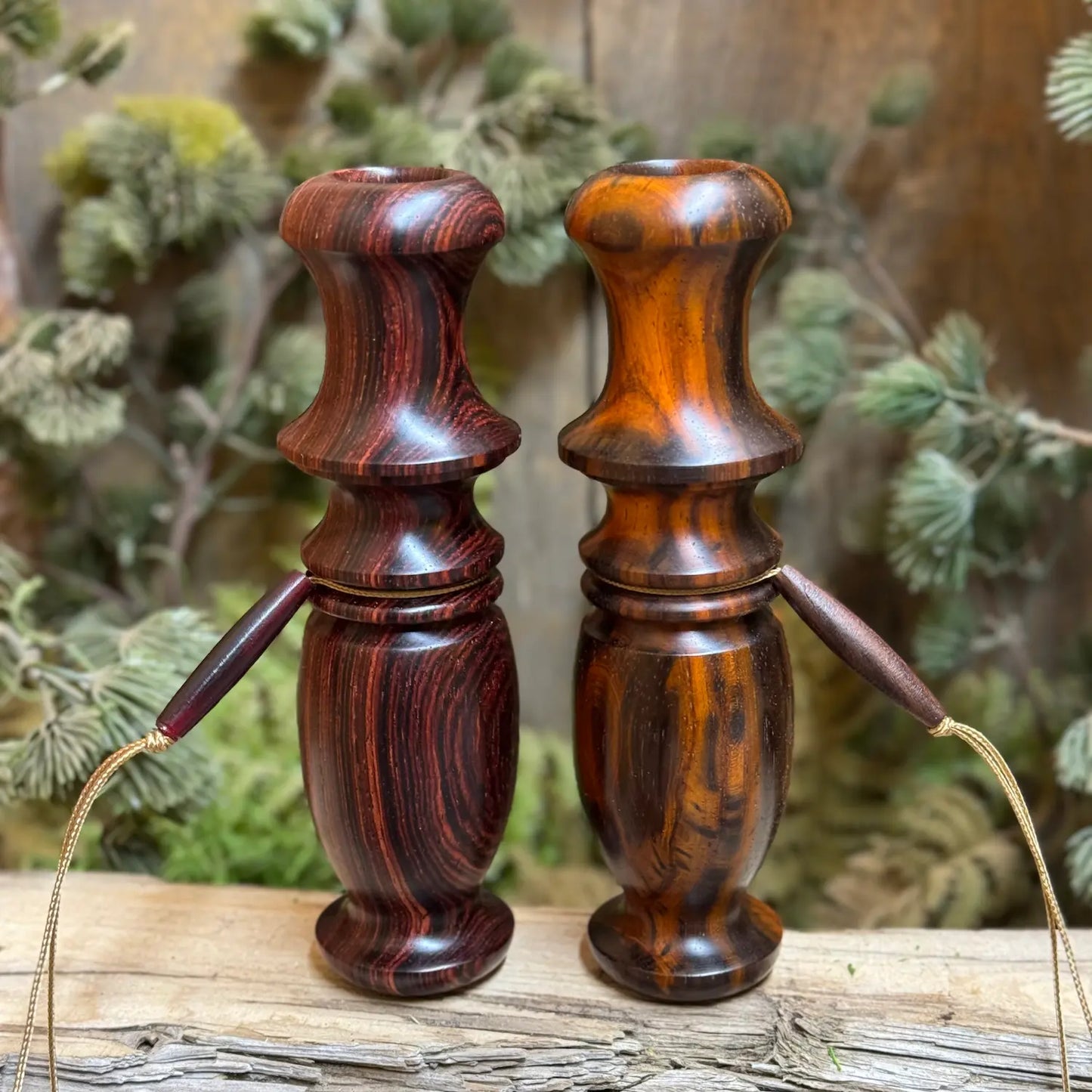 A Pair of Cocobolo wood Compact Whitetail Grunt Calls show golden bronze hues in one call and red and chestnut tones in the other call