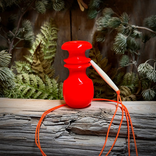Glowing bright, this little Hunter's Orange blacktail call sits on display with a beaded lanyard in matching orange