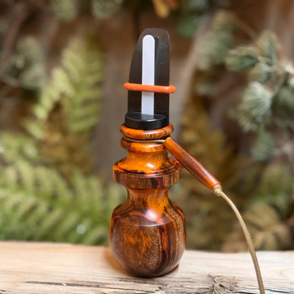 Unique wood grain in this Asian Mohagany Burl Elk Call shows sappy inclusions and red veins along the grey undertones of the burl. This elk call is a one of a kind piece showing quality craftsmanship.