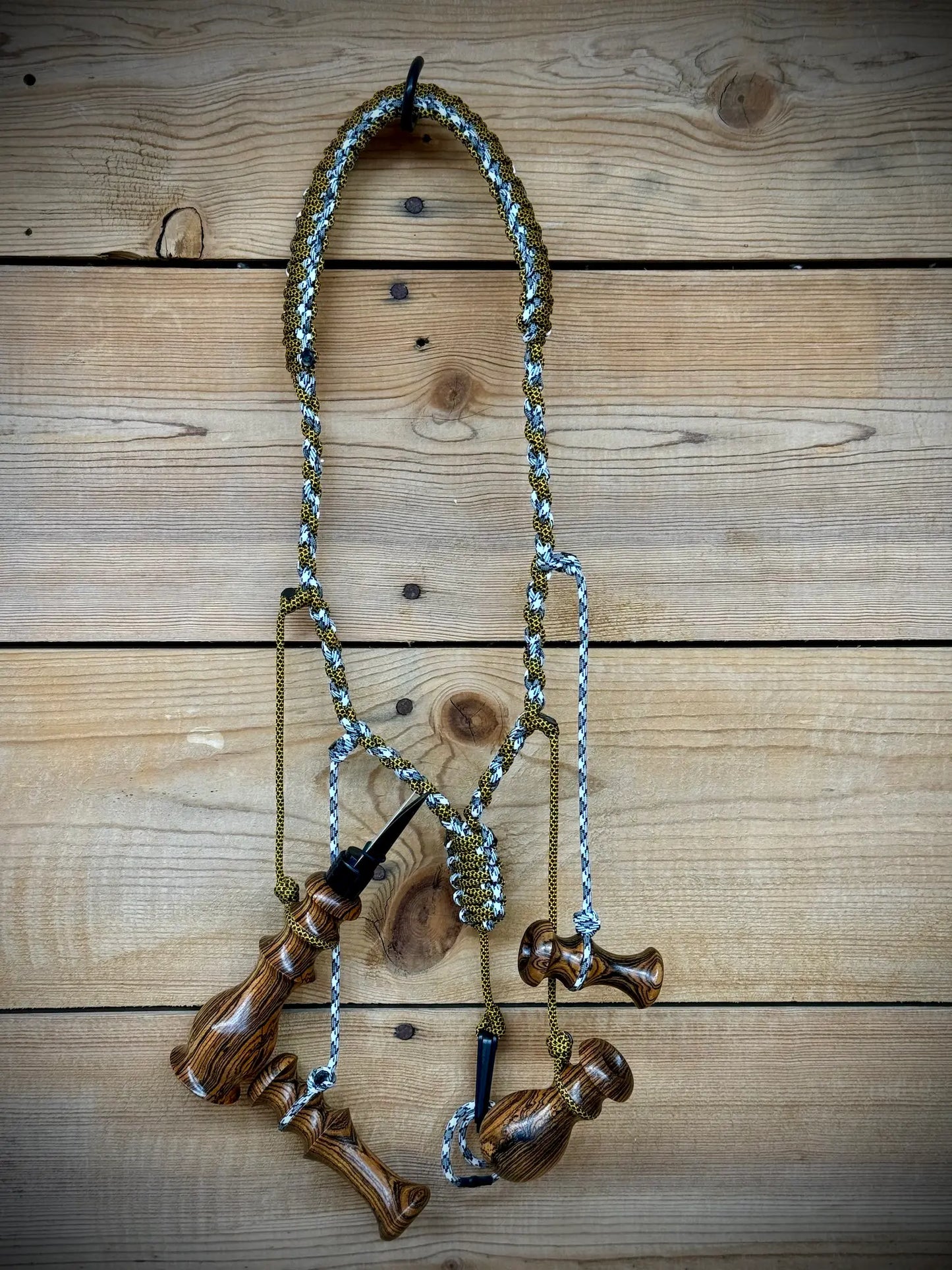 Bocote Predator Call Set Close Up View with rabbit squealer, coyote howler, fawn distress bleat, and rodent squeaker hanging from a custom made lanyard woven with aqua blue and yellow and black cords