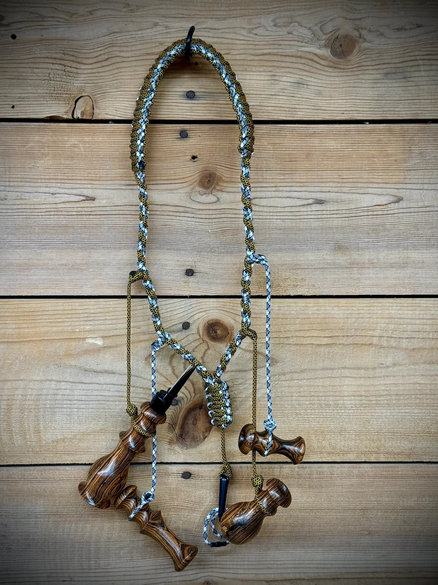 Bocote Predator Call Set Close Up View with rabbit squealer, coyote howler, fawn distress bleat, and rodent squeaker hanging from a custom made lanyard woven with aqua blue and yellow and black cords