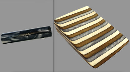 swatch of swirling black and grey tone acrylic rod next to Buckskin laminate wood pattern of alternating grey, copper, and creme tones separated by black dividing lines
