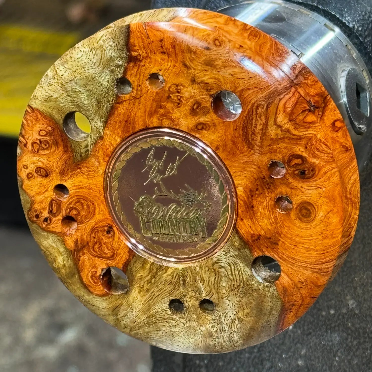 Amboyna Burl Turkey Pot Call with Golden Medallion displayed on the Lathe chuck