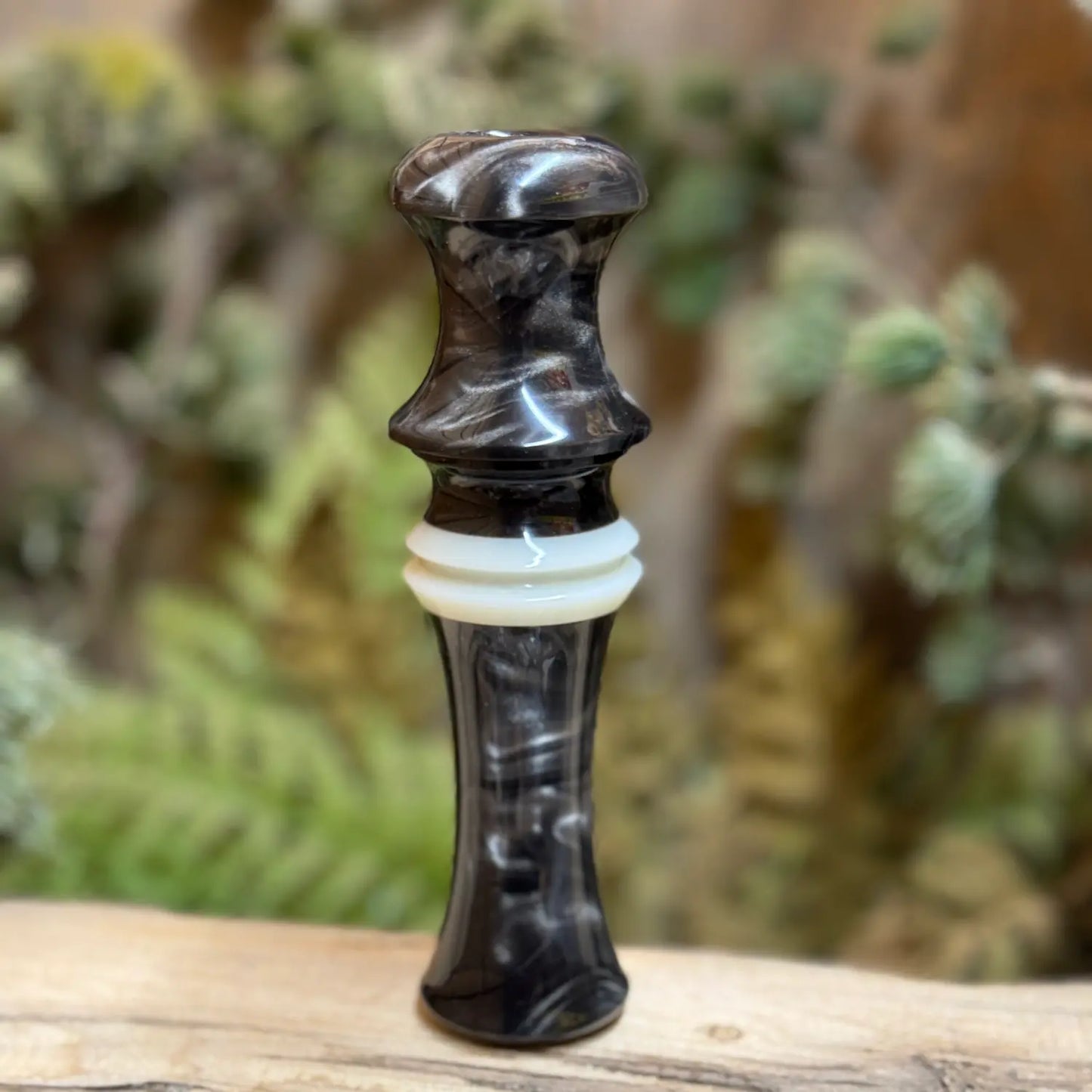 Short Reed Goose call made with the signature swirling acrylic patterns of silver and brown like smoky on carbon. HD Carbon Acrylic from Deadshot Polymer's with white central faux ivory ring with built-in lanyard groove.