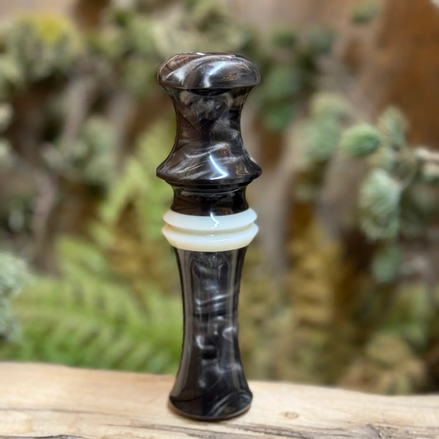 Short Reed Goose call made with the signature swirling acrylic patterns of silver and brown like smoky on carbon. HD Carbon Acrylic from Deadshot Polymer's with white central faux ivory ring with built-in lanyard groove.