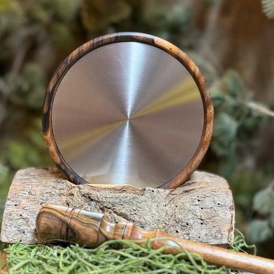 Titanium glimmers a brushed silver tone in this mun ebony turkey pot call. A Custom matching striker lays across the front of the scene.