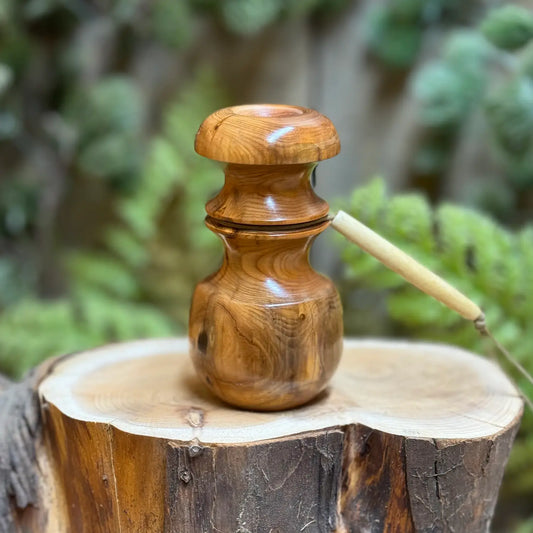 a glossy and golden Pacific Yew Wood Blacktail Bleat call resting on a milky toned fresh cut stump