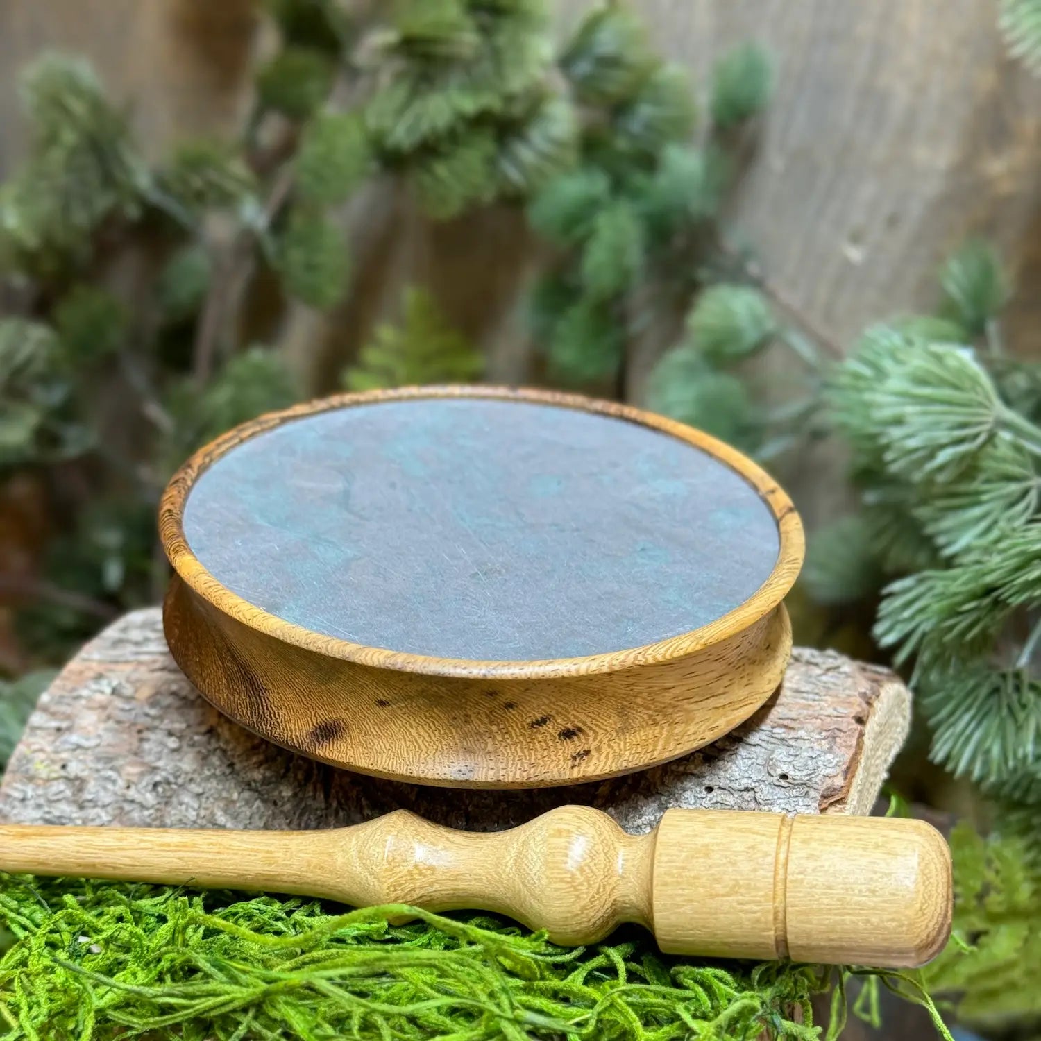 Pheasantwood Turkey Pot Call with purple slate surface and lighter sapwood contrasts with warmer wood figuring in the grooved edge set atop a lighter toned black locust wood striker