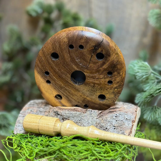 pheasantwood turkey pot call beautifully made with character in the wood grain seated next to a light toned black locust wood striker 