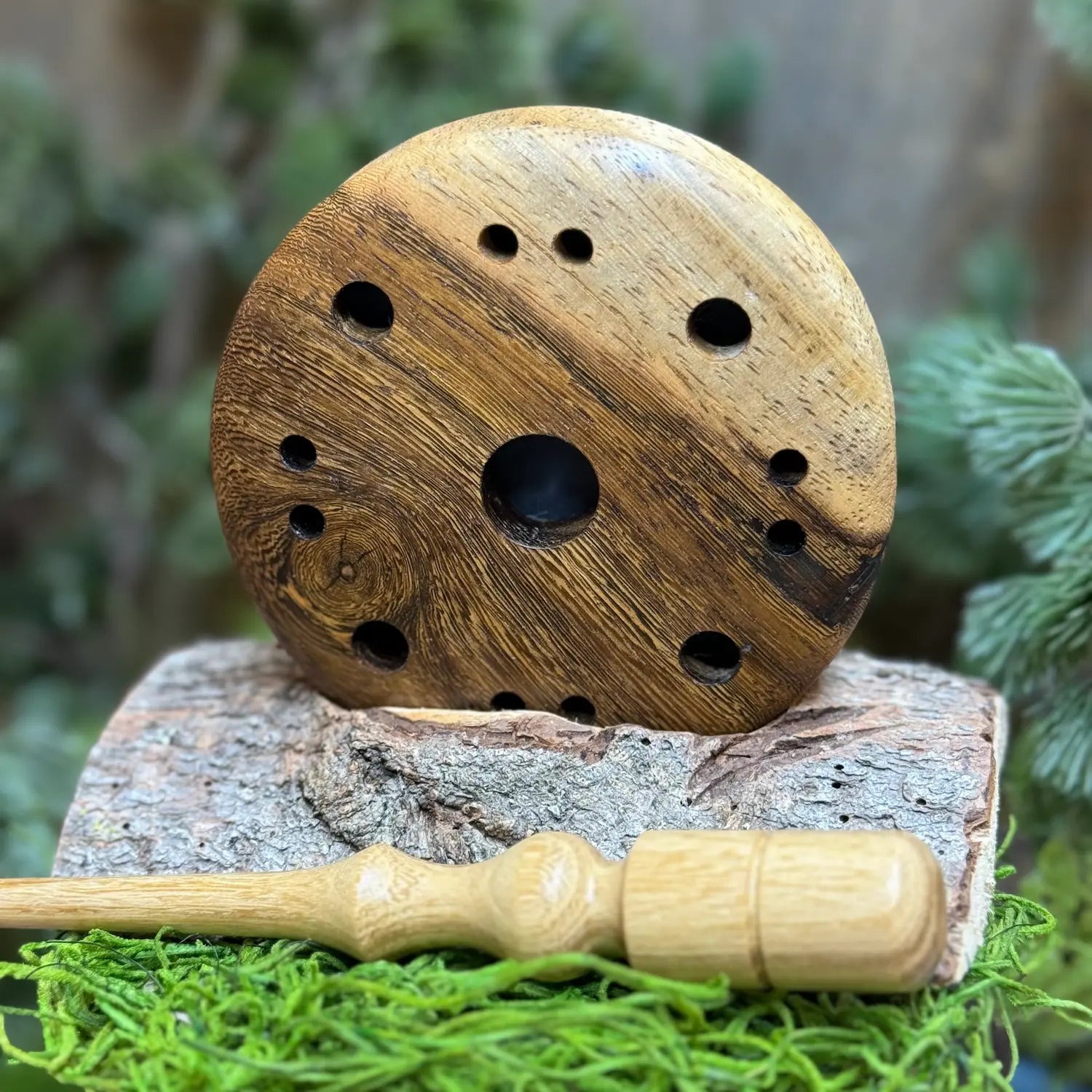 Pheasantwood Turkey Pot Call with lighter sapwood contrasts with warmer wood figuring propped up behind a lighter toned black locust wood striker