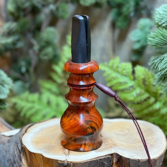 rich red and bronze tones in luxurious dark wood grain of siamese rosewood hand crafted into a beautiful crow call with custom lanyard and mouthpiece